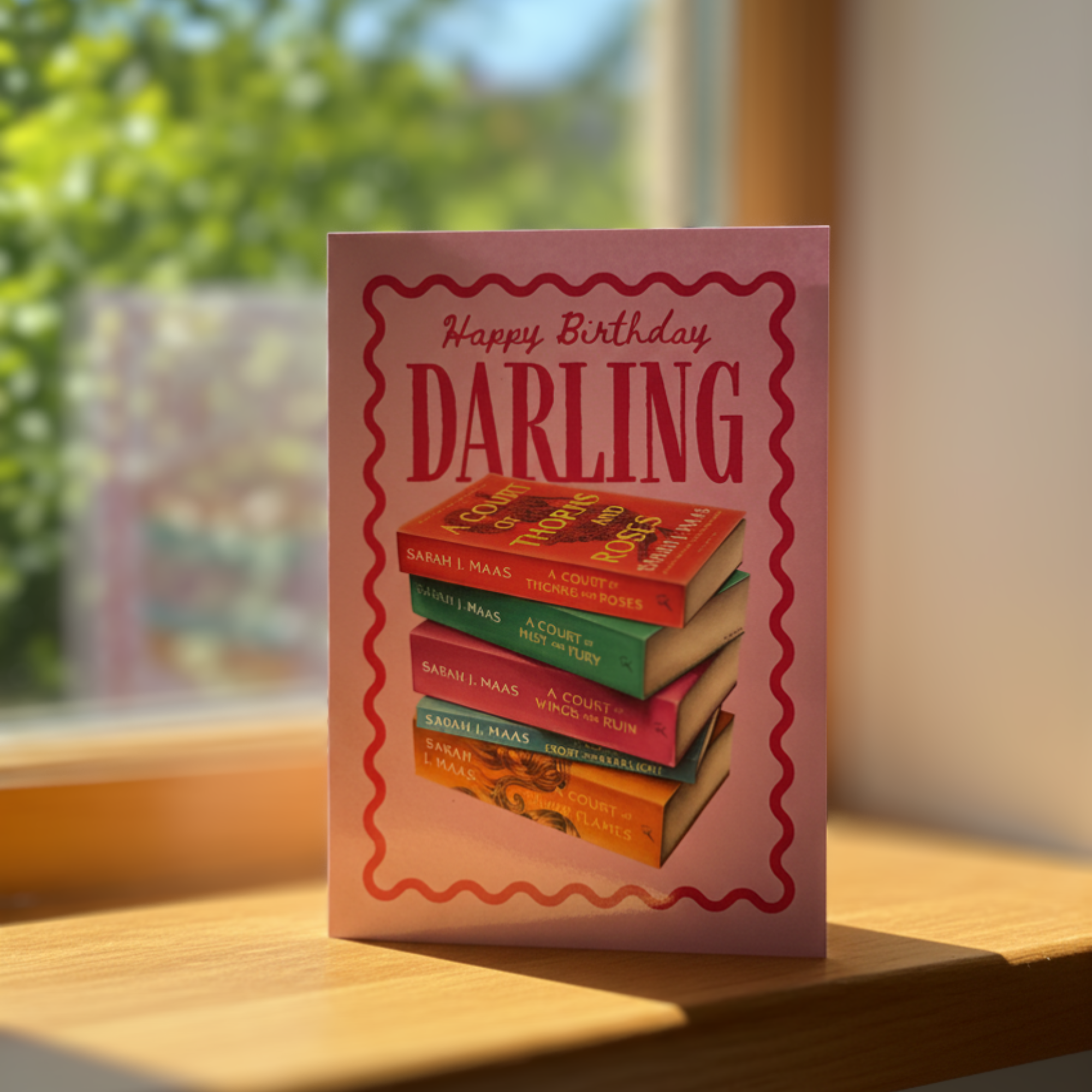 Birthday card with book stack design and ‘happy birthday darling’ text on a sunny windowsill