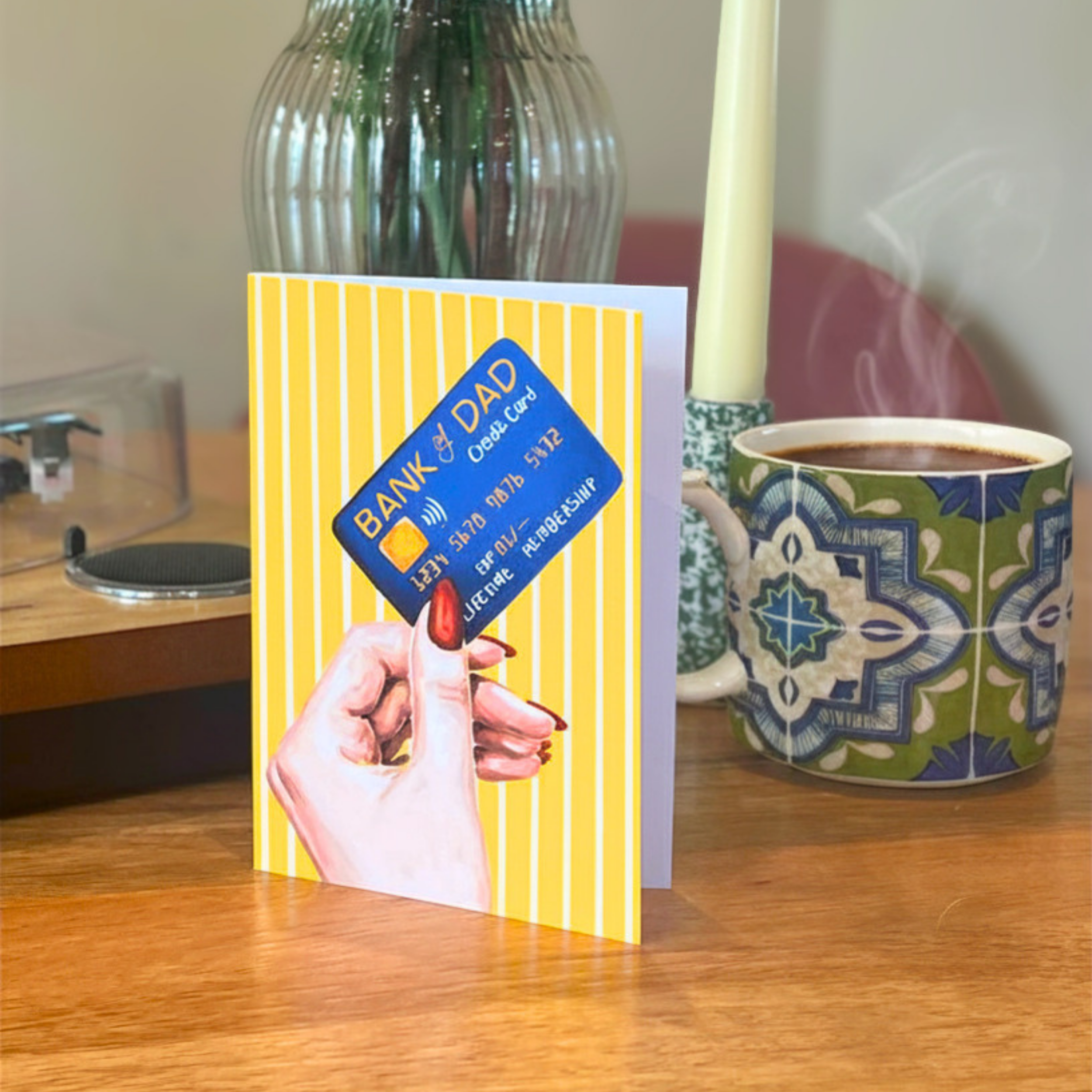 Fathers day card with a credit card design on a table with a mug and candle