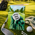 Greeting card with a gloved hand holding a golf ball labeled 'World's Best Dad' against a golf course background. Displayed on a golf course