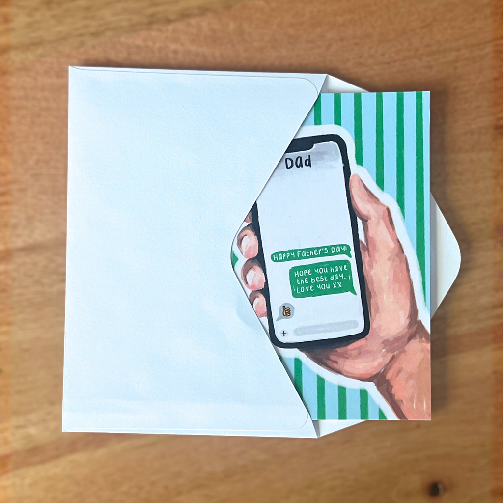 Father’s day card with a phone and text on a wooden surface