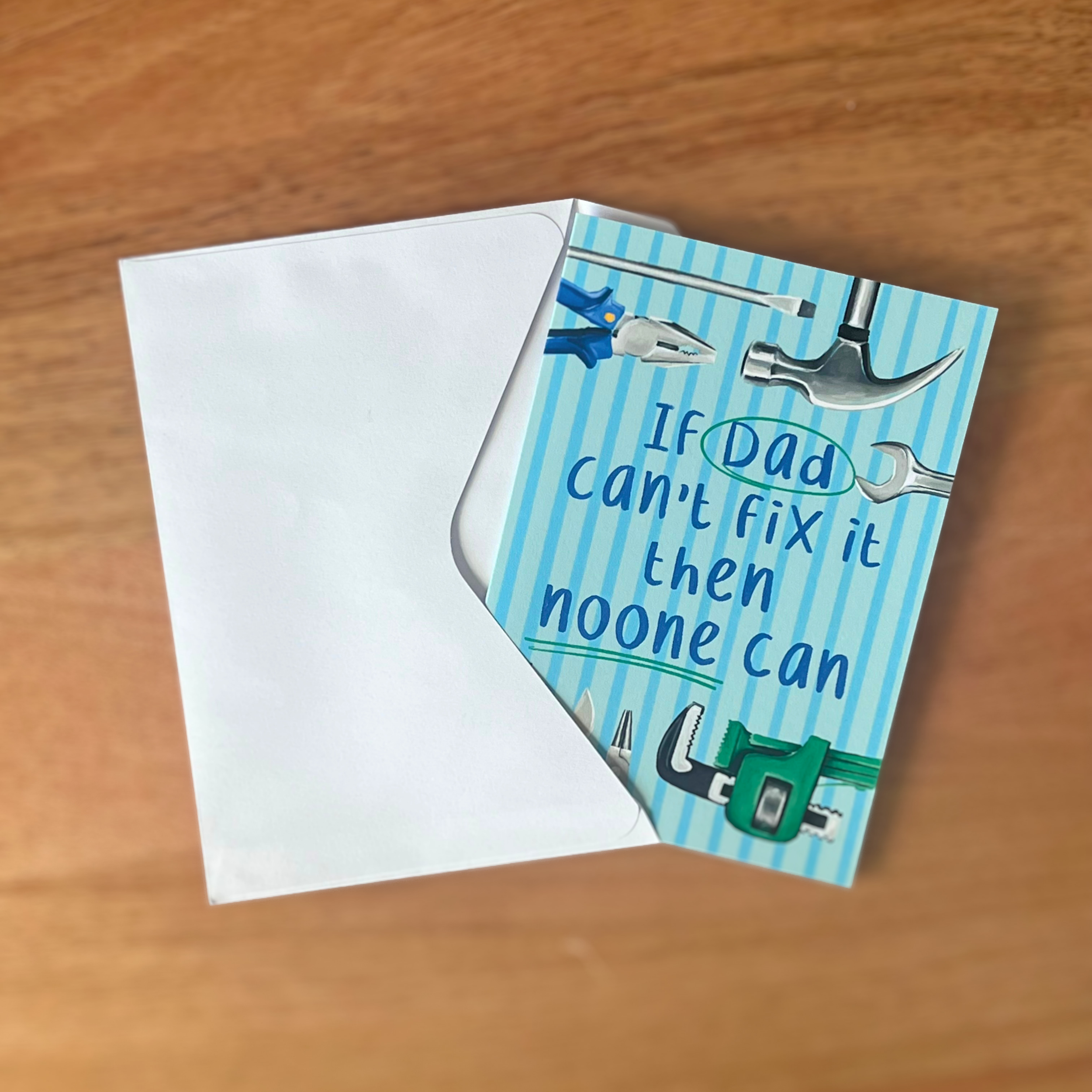 Fathers day card with tools illustration and text on a wooden surface