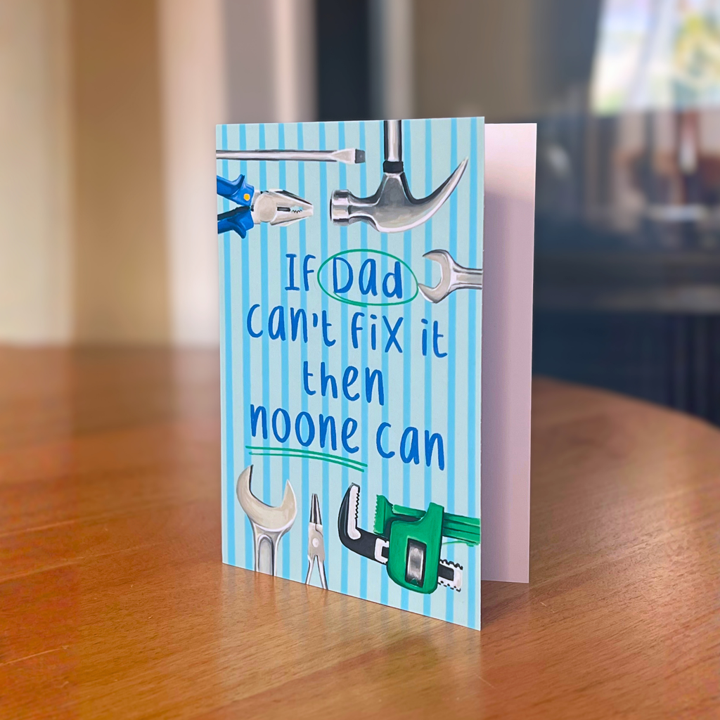 Fathers day card with tools and text on a wooden surface