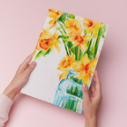 hands holding an art print of watercolour daffodils