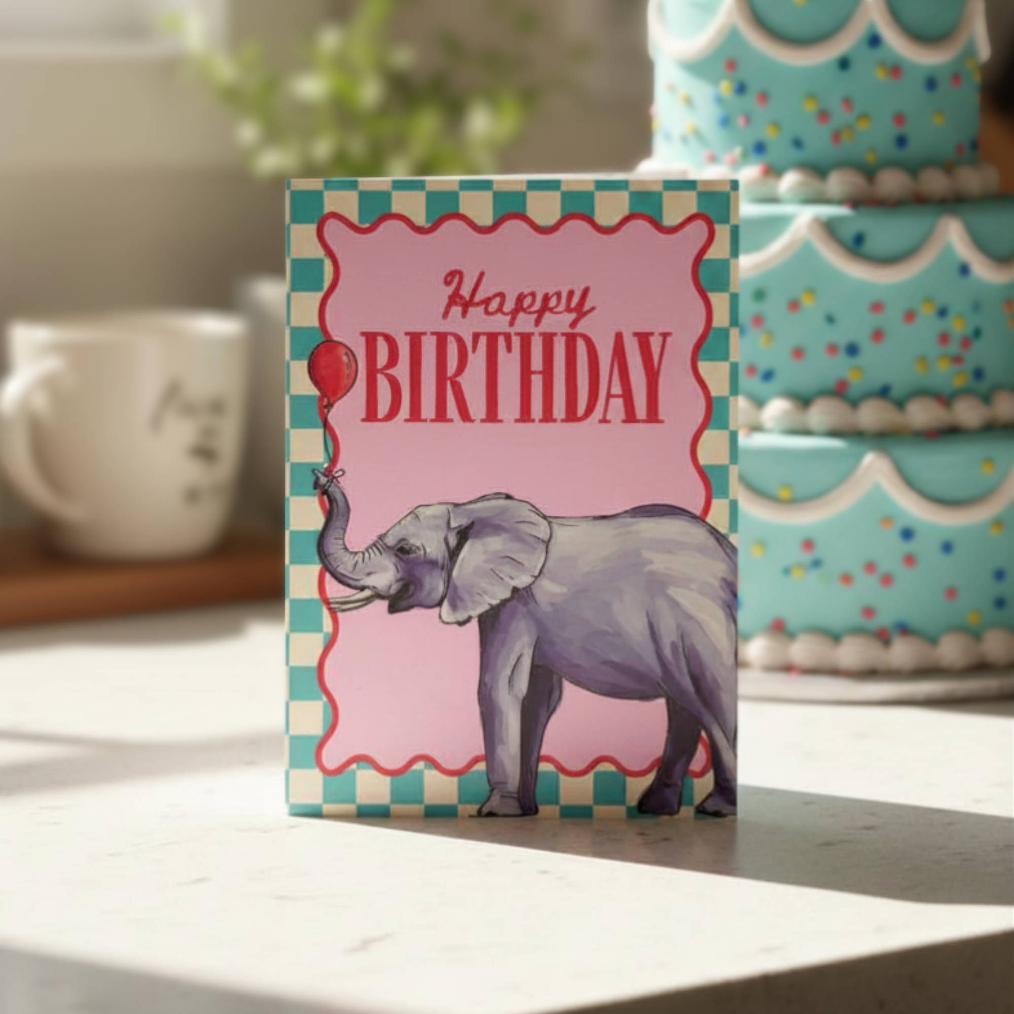Birthday card with an elephant illustration on a table with a cake in the background