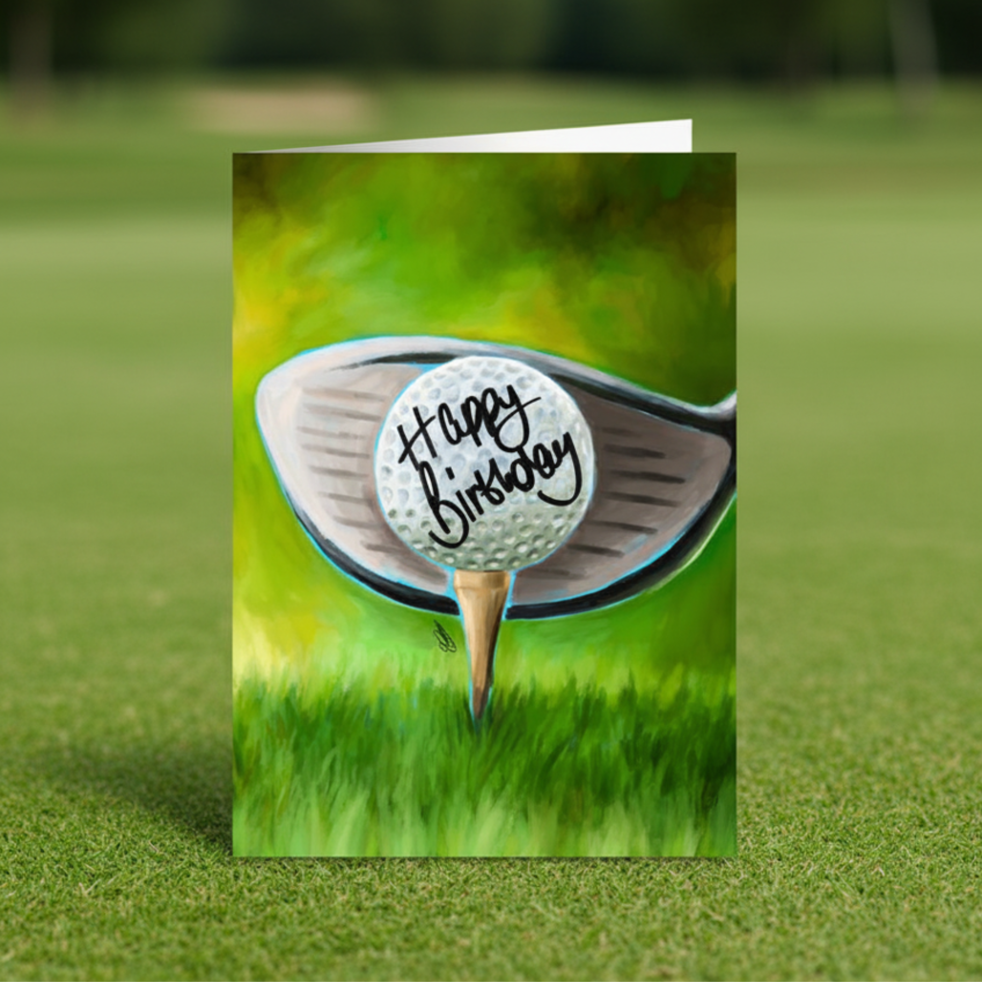 Greeting card with a golf ball and club on a grass background, featuring 'Happy Birthday' text. Displayed on a golf green