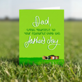 Father's Day card with funny message and lawn mower illustration on a green background stood in the grass