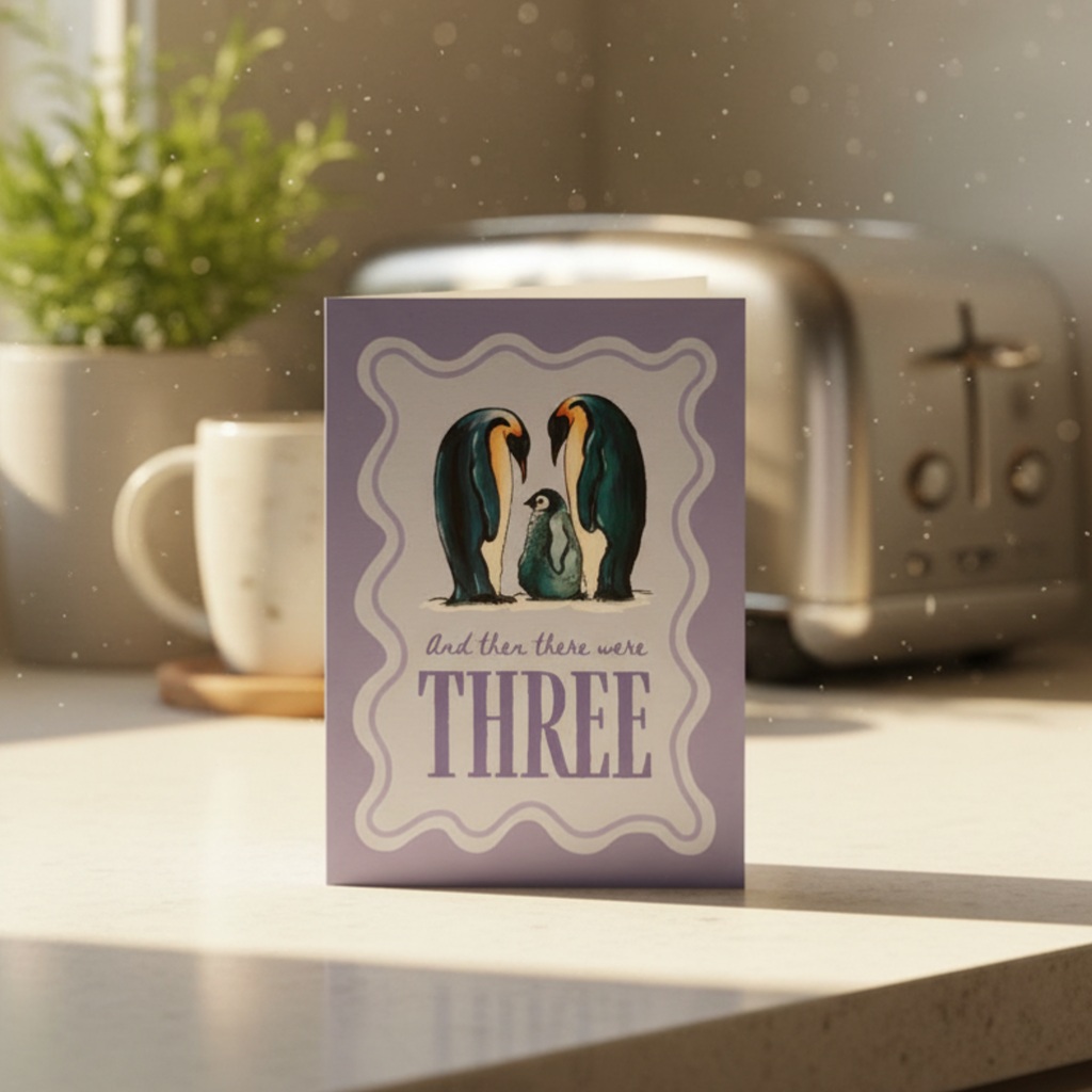Card with penguin family illustration on a kitchen counter