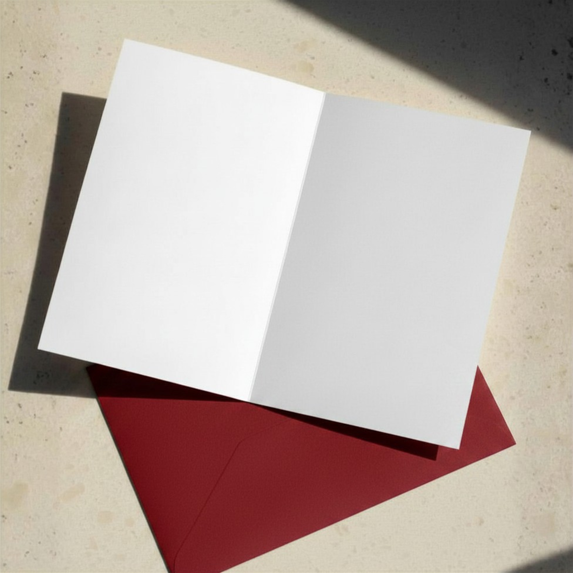 Blank greeting card layer open on a red envelope on a sunny kitchen counter