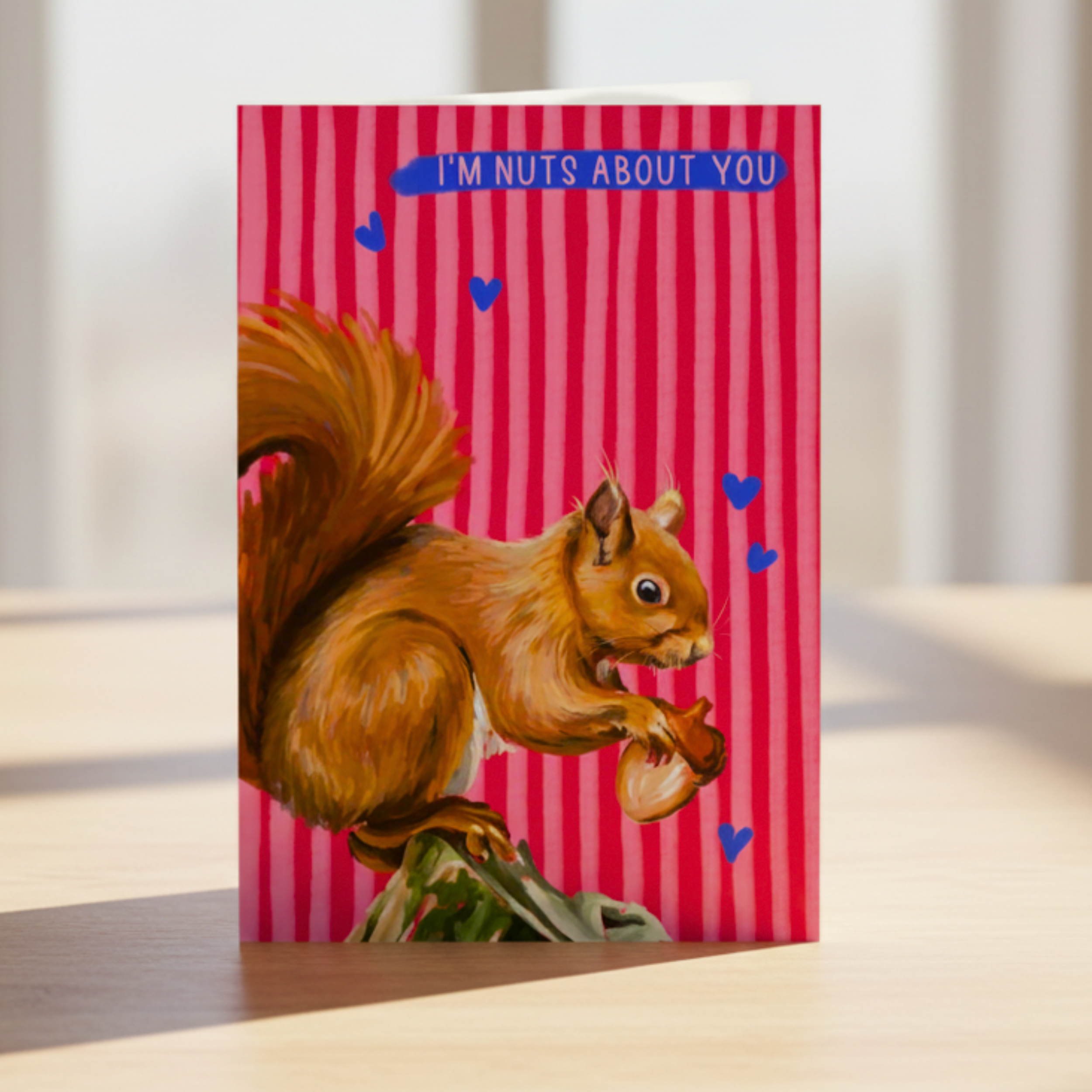 Card with a squirrel illustration and 'I'm nuts about you' text on a red striped background.