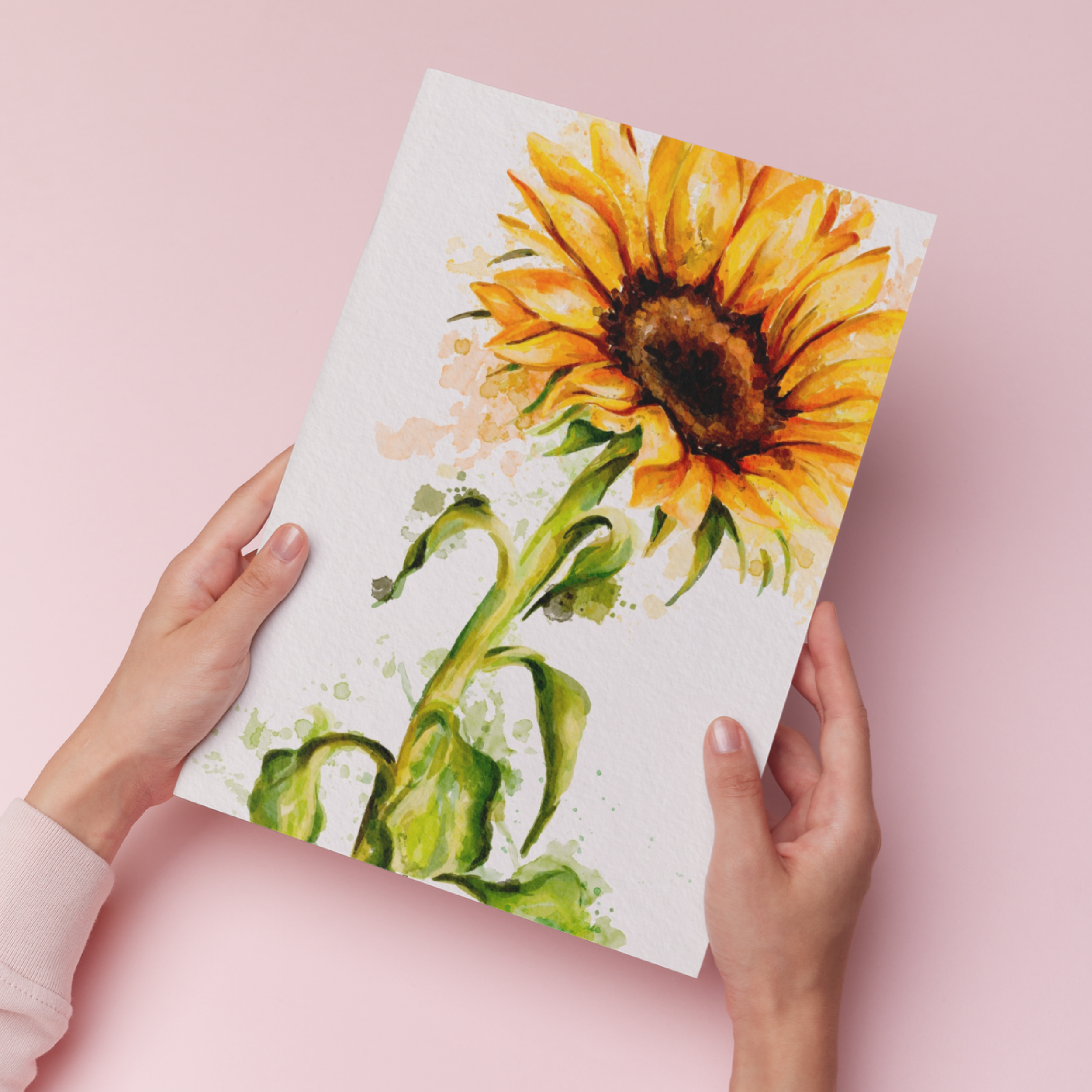 Hands holding an art print of a watercolour sunflower