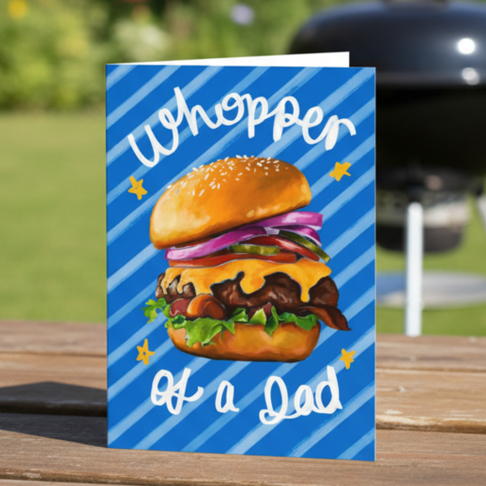 Father’s Day card with Illustration of a burger with text 'Whopper of a Dad' on a blue striped background.